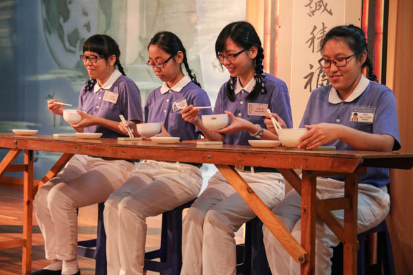 在慈青营队“礼仪之美”课程中,四位学员上台示范慈济人的「龙口含珠,凤头饮水,以食就口」,让学员学习如何端碗、拿筷、就食。(摄 / 余政辉)